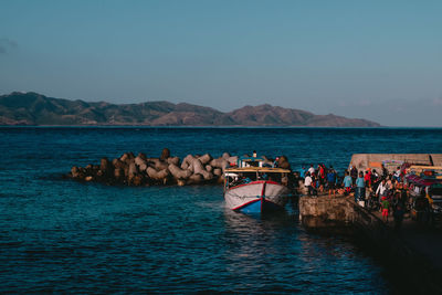 People on sea against clear sky