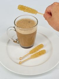 High angle view of hand holding coffee served on table