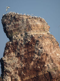 Low angle view of rock formation against clear blue sky