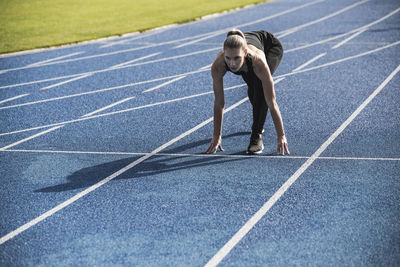 Young athlete at starting line of track