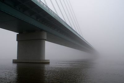 Bridge over river vistula during foggy weather