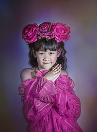 Portrait of a smiling girl against pink background