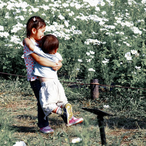 Full length of mother and daughter standing on tree