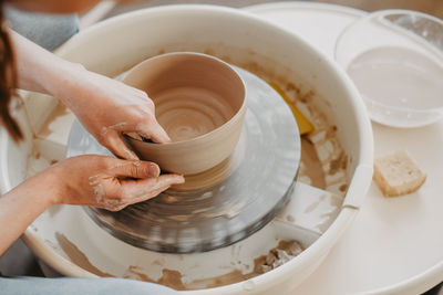 Pulling out the walls of clay product on potters wheel