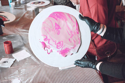 Cropped hand of woman holding paint in plate