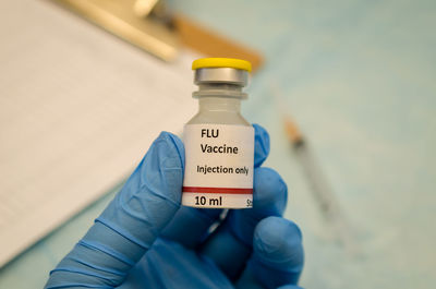 Close-up of human hand holding bottle in laboratory