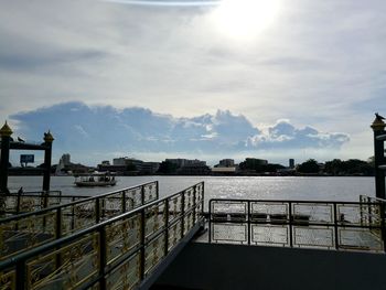 Bridge over river in city against sky