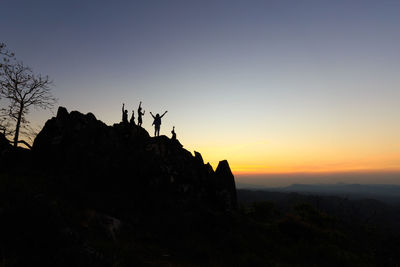 People standing on silhouette landscape