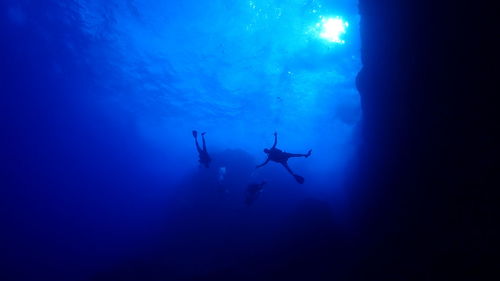 Low angle view of people swimming in sea