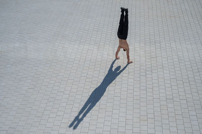 High angle view of man doing handstand on street