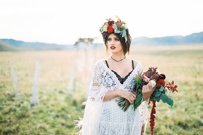 Beautiful woman with flower bouquet in field
