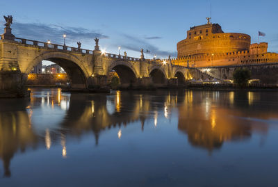 Illuminated bridge over river against sky