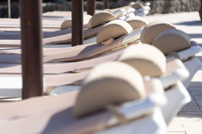 Close-up of deck chairs in row at sea