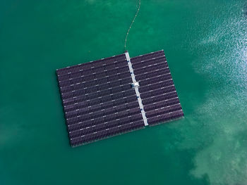 Aerial view of floating solar farm in a lake with many solar panels