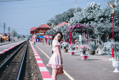 Portrait of young woman standing on railway station platform