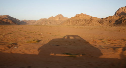Shadow on sand in desert against sky