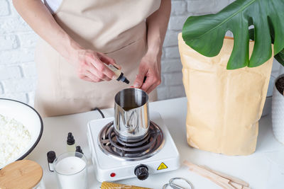 Midsection of woman preparing coffee at table