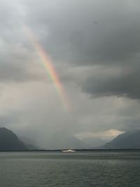 Scenic view of rainbow over sea against sky