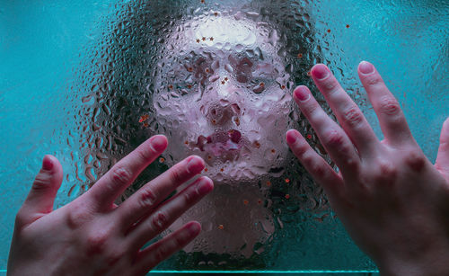 Close-up of woman seen through wet glass