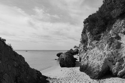 Scenic view of rocks on beach against sky