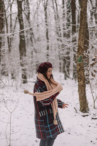 Young woman standing on snow covered field