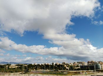View of cityscape against cloudy sky