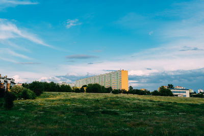 Buildings on field against sky