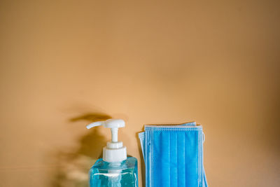 Close-up of blue bottle against wall at home