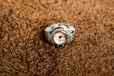 Close-up of clock on rug