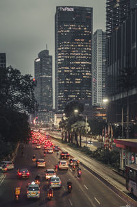 Traffic on city street amidst buildings at night