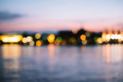 Defocused image of illuminated lights in city at night