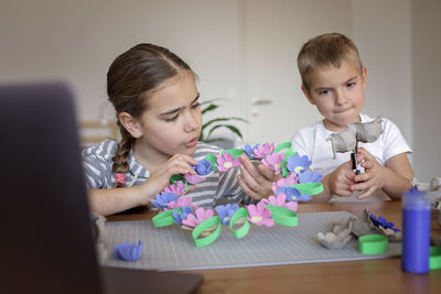 Kids create easter flower wreath in pastel colors using an upcycled egg trail. zero waste lifestyle