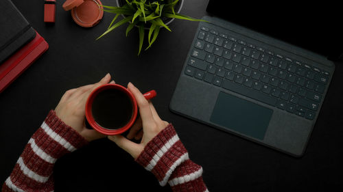 High angle view of woman hands holding coffee cup