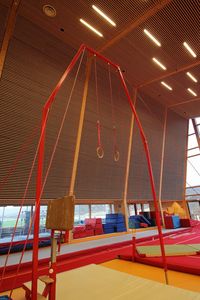 Low angle view of illuminated lighting equipment hanging in building