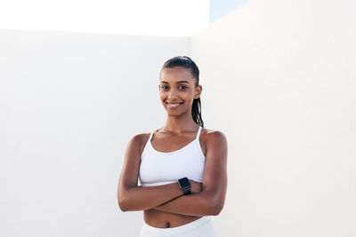 Portrait of young woman standing against white background