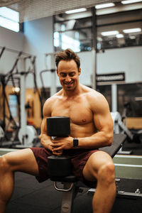 Shirtless man exercising in gym