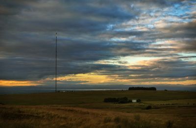 Scenic view of field against cloudy sky