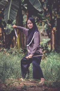 Portrait of young woman standing in forest