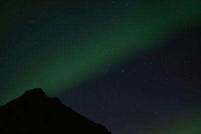 Low angle view of silhouette mountain against sky at night