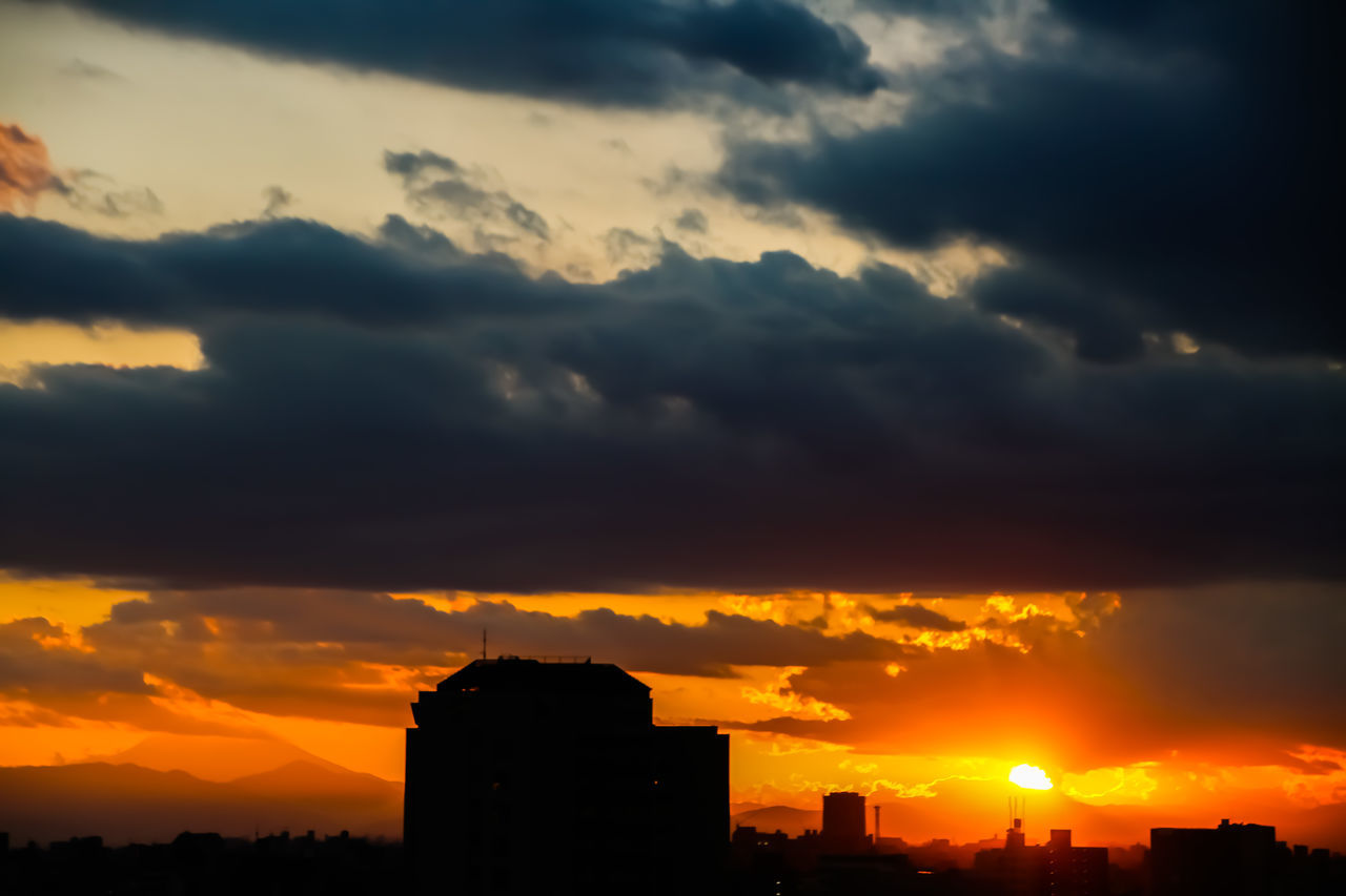 SILHOUETTE BUILDINGS AGAINST ORANGE SKY