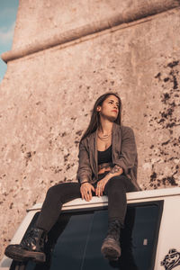 Portrait of young woman sitting outdoors