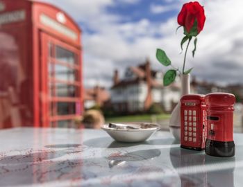 Close-up of model telephone booth and flower vase on table