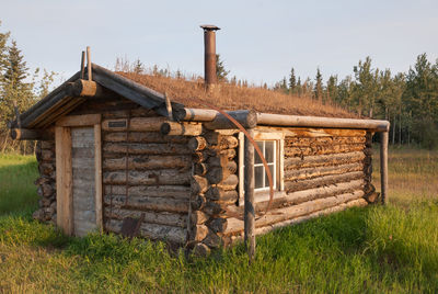House by tree against sky