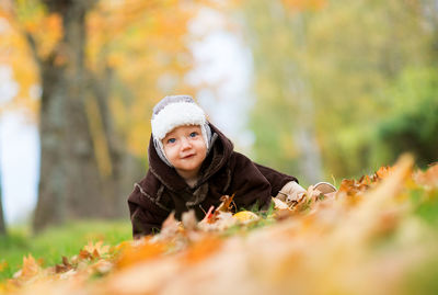 Surface level view of baby boy sitting at park during autumn