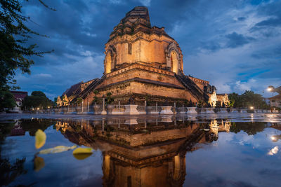 Reflection of illuminated building against sky at night