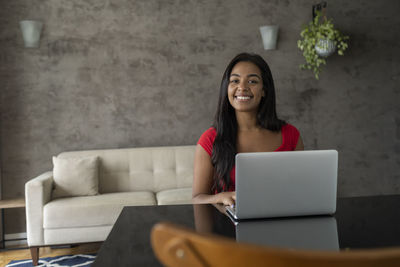 Young black woman working at home with laptop on desk. home office concept. gray notebook. 