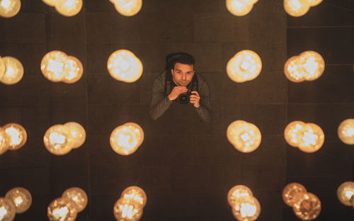 Portrait of man amidst illuminated lights