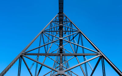 Low angle view of communications tower against blue sky