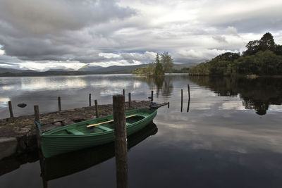 Boats moored in lake against sky