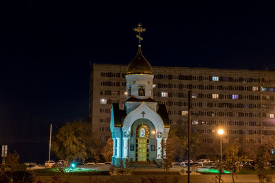 Low angle view of illuminated building against sky at night